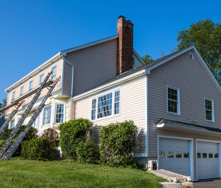A ladder leaning to the external wall of a house, wherein the sidings are successfully installed