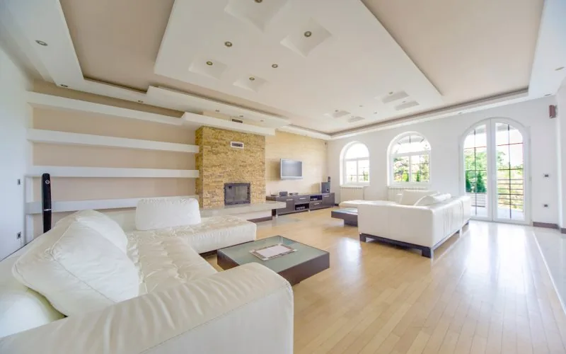 Interior of a luxurious house with wide living room and long couches.