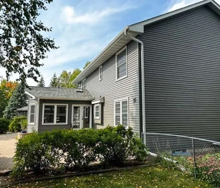 Vinyl Siding of a two-story of a house with concrete backyard patio