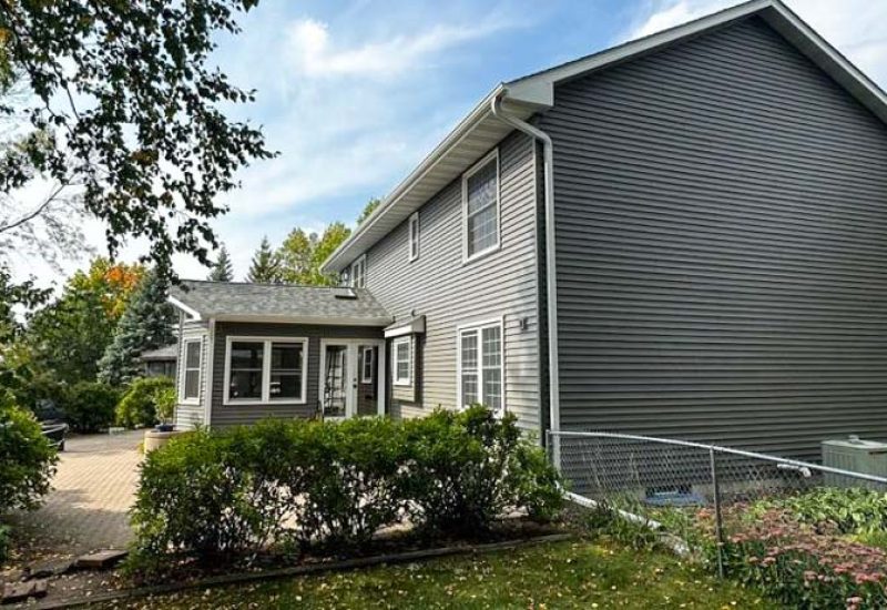 Vinyl Siding of a two-story of a house with concrete backyard patio
