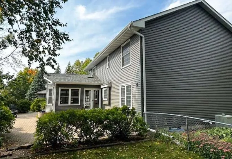 Vinyl Siding of a two-story of a house with concrete backyard patio