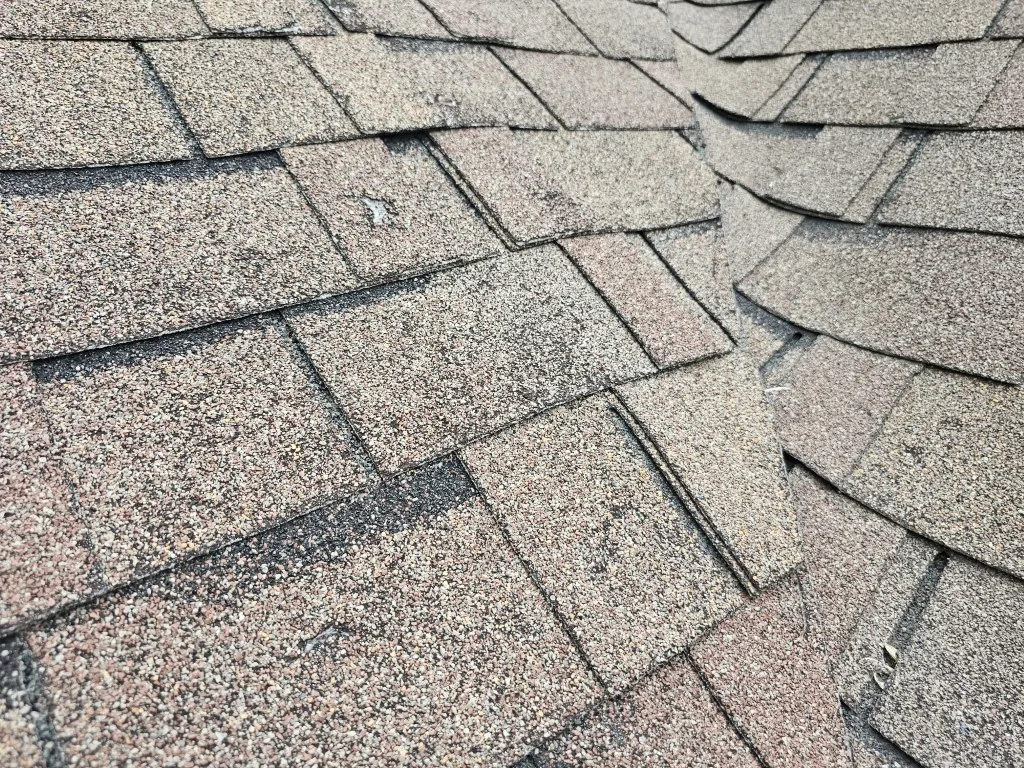 Hail-damaged roof in Prior Lake, MN before replacement by BN Exteriors, LLC showing impact damage on shingles