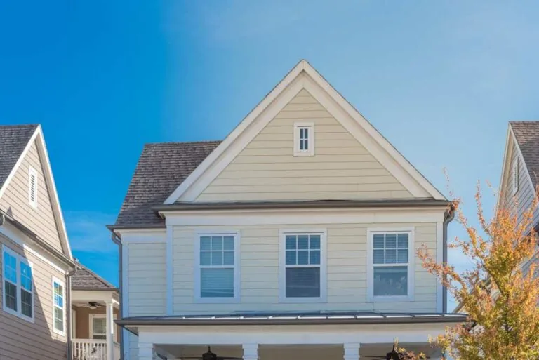 Upscale cottage style homes in suburbs Dallas, Texas with wood siding, covered porch patio with ceiling fans. Colorful autumn leaves and white cladding layer thermal insulation, weather resistance